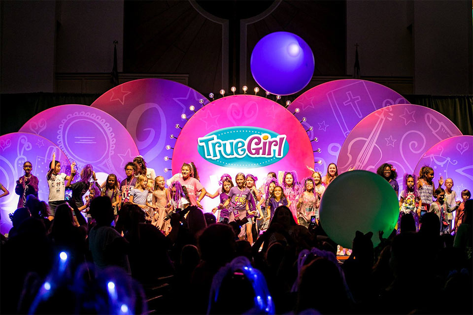 A group of girls standing on a stage at a True Girl event