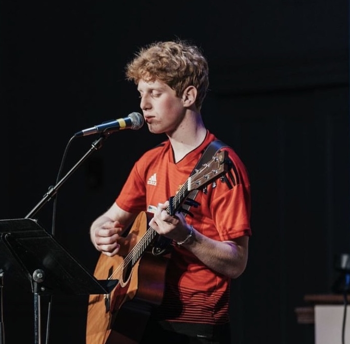 Colson Erb playing the guitar and singing